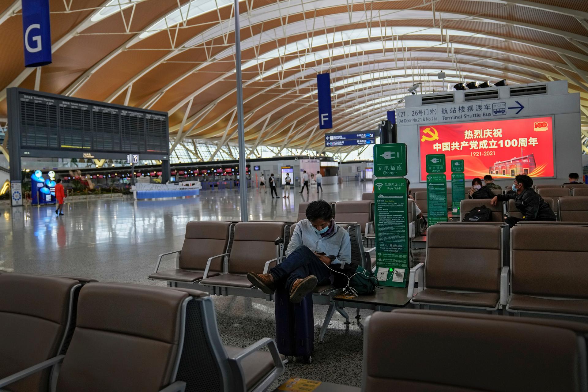 Passengers wearing face masks to help protect against the coronavirus take rest at Pudong International Airport in Shanghai, China on July 25, 2021.