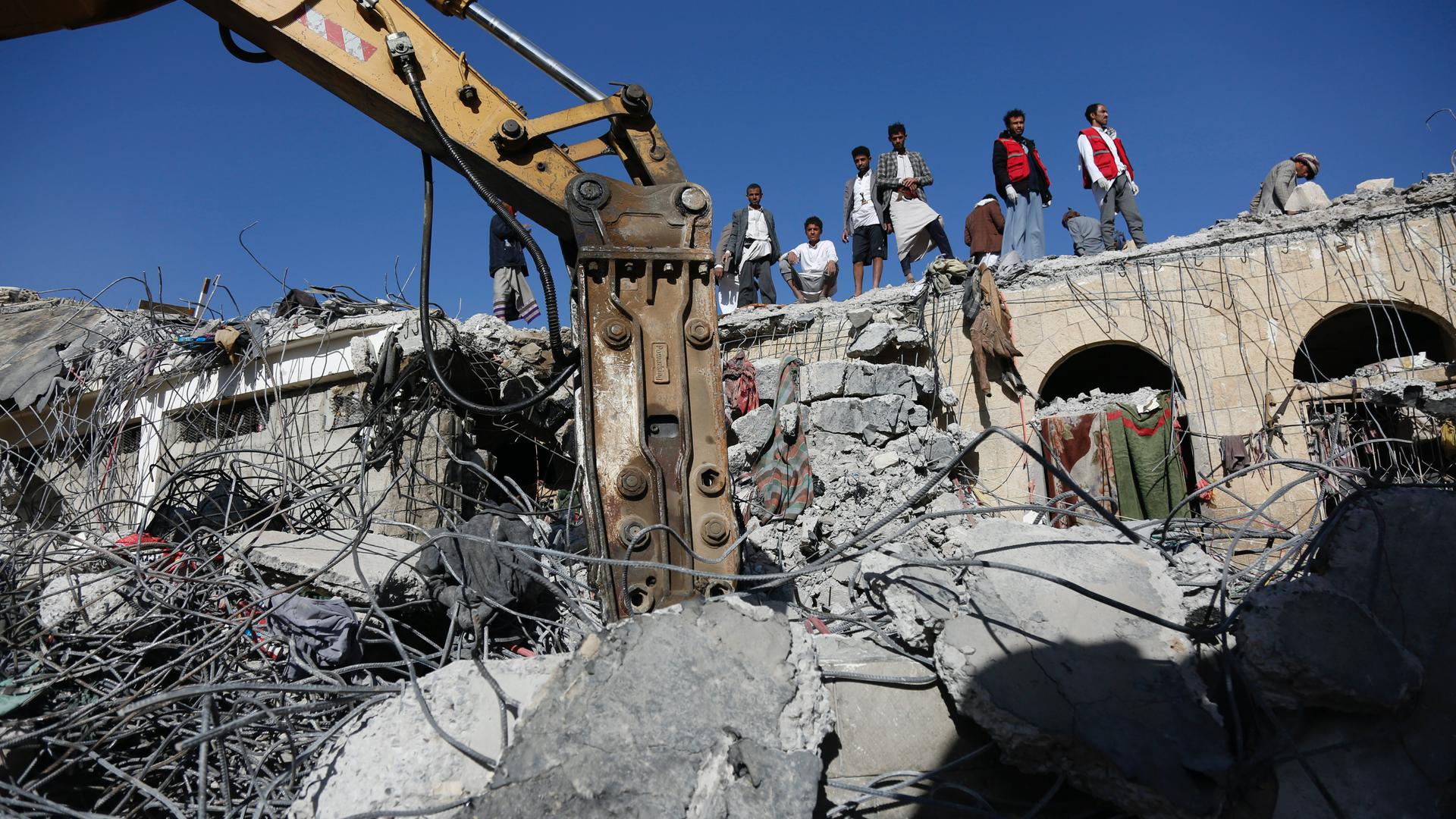 People inspect the rubble of a prison facility hit by a Saudi-led coalition airstrike in a stronghold of Houthi rebels on the border with Saudi Arabia, in the northern Saada province of Yemen, Jan. 22, 2022. Internet access remained largely down for four