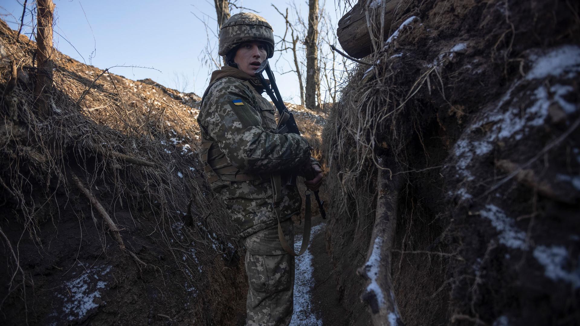 A Ukrainian soldier stands in the trench on the line of separation from pro-Russian rebels, in Mariupol, Donetsk region, Ukraine, Thursday, Jan. 20, 2022. 