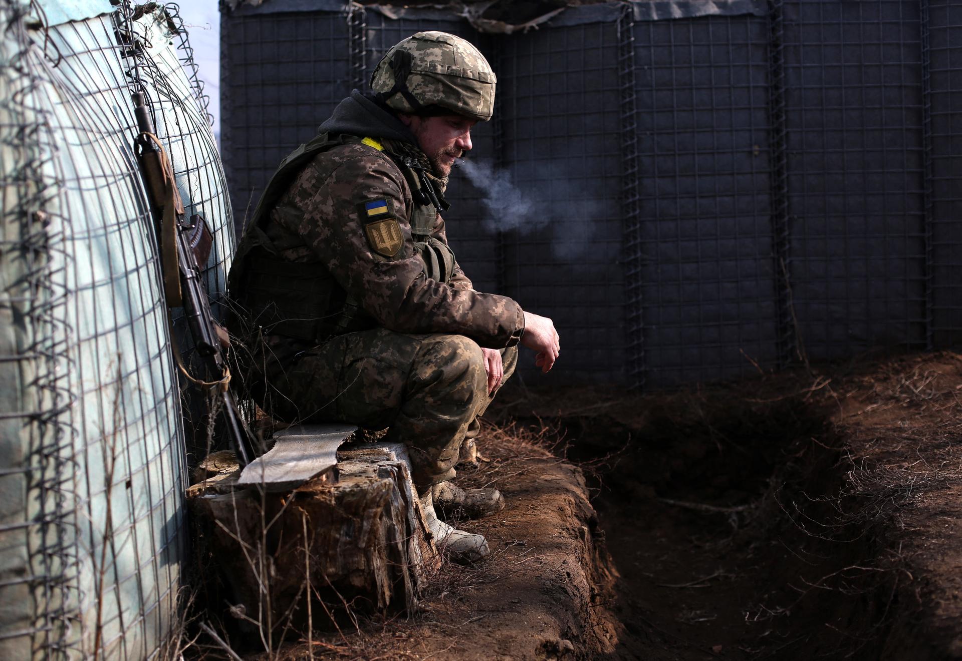 A Ukrainian soldier smokes a cigarette near the front line with Russia-backed separatists in Lugansk, Ukraine, on Feb. 22, 2022.