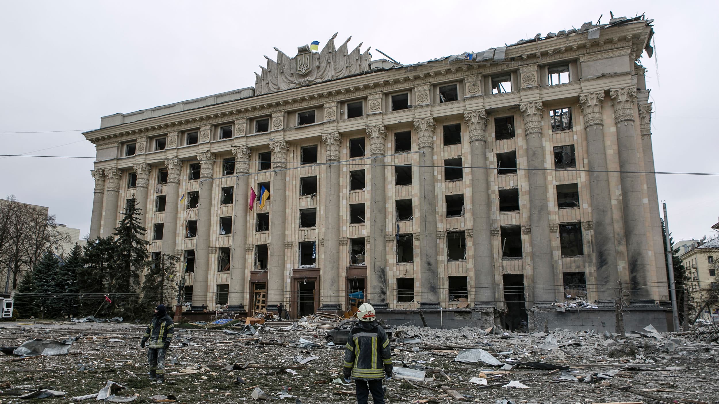 A member of the Ukrainian Emergency Service looks at the City Hall building in the central square following shelling in Kharkiv, Ukraine, Tuesday, March 1, 2022. 