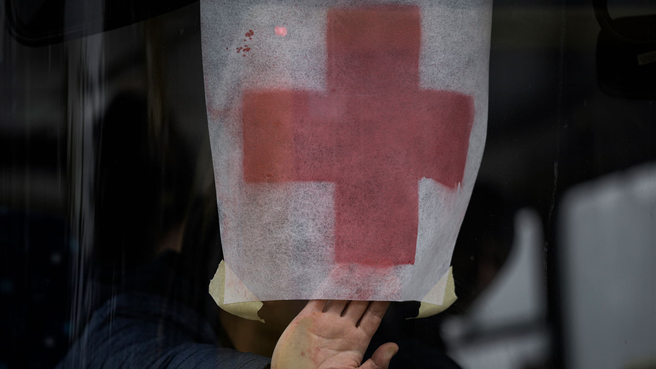 A man presses a paper with the red cross on it against the windshield of a bus as civilians are evacuated from Irpin, on the outskirts of Kyiv, Ukraine, Wednesday, March 9, 2022.