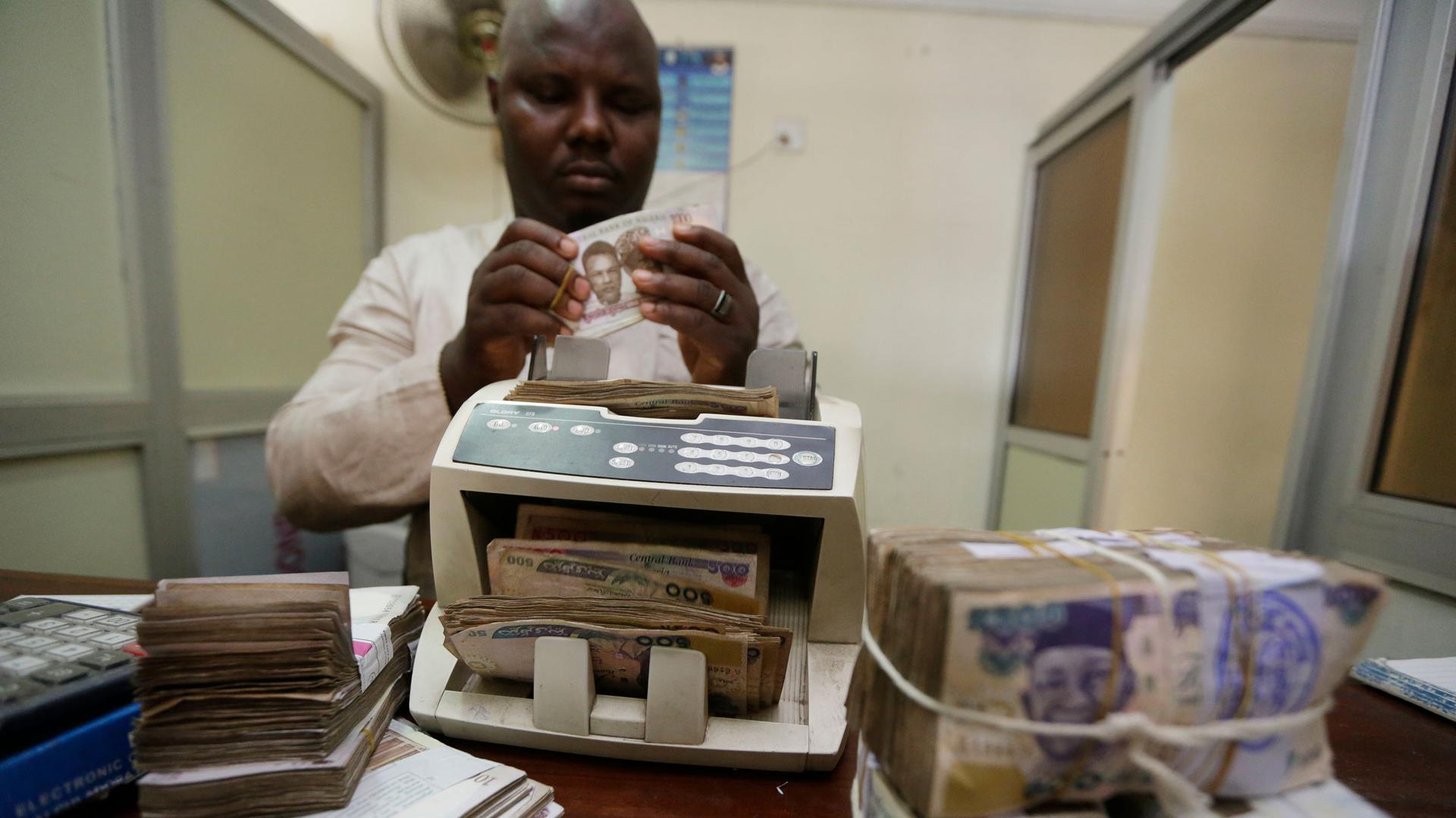 A money changer counts Nigerian naira currency at a bureau de change, in Lagos Nigeria, Oct. 20, 2015.