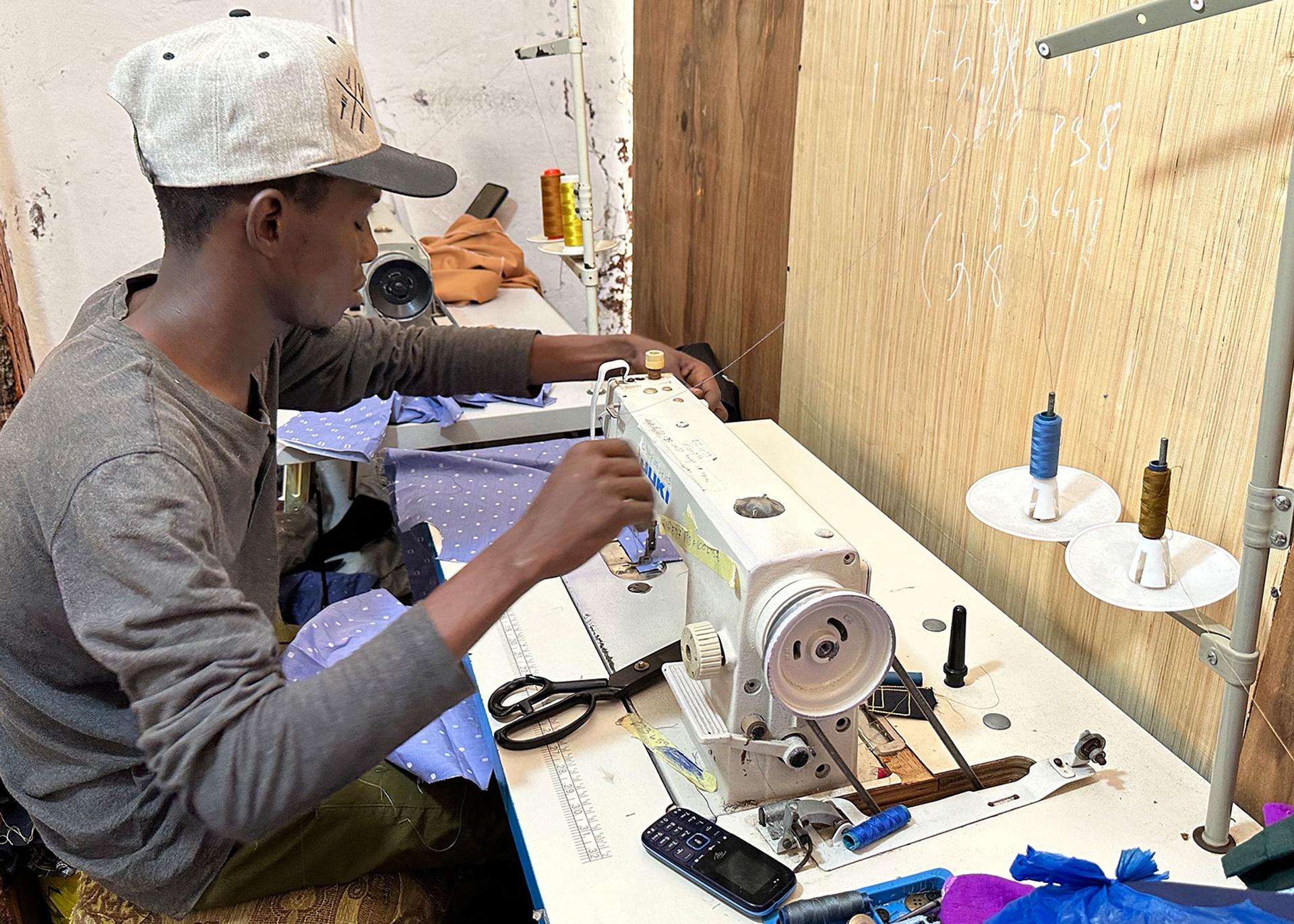 A young worker sews clothes at the Mar Design tailor shop in St. Louis, Senegal.