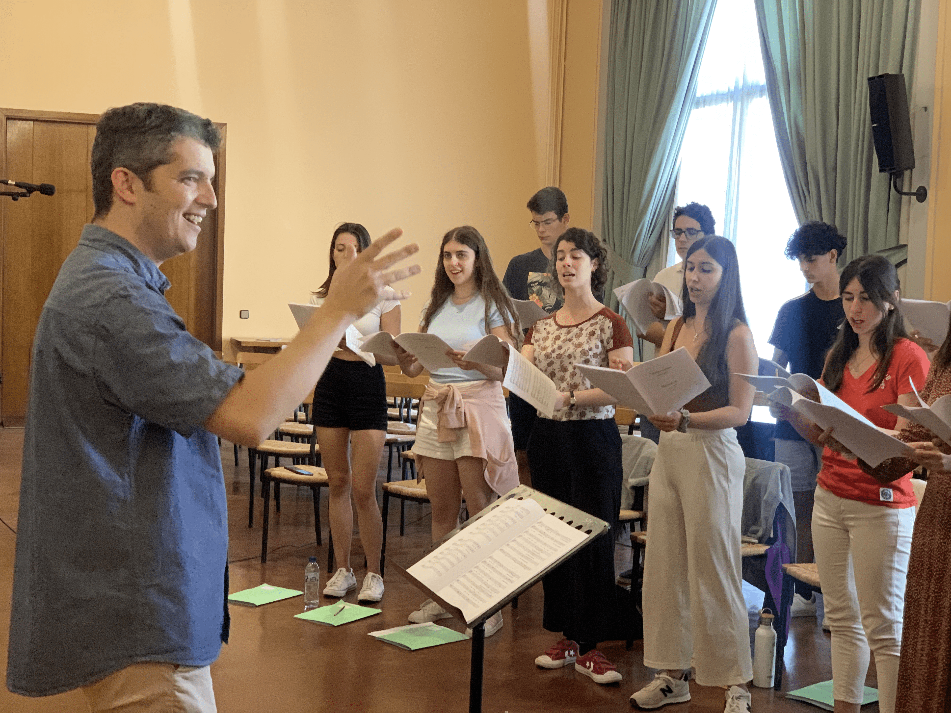 Mixed choir director Pau Jorqueras directing a room full his female choir singers
