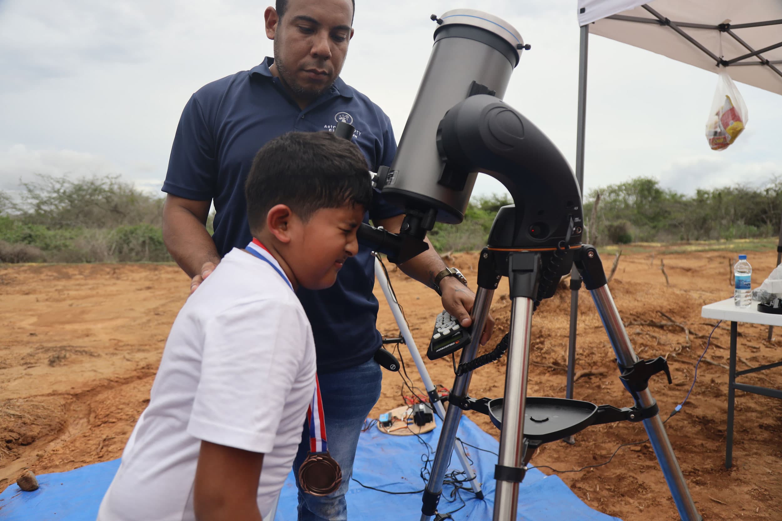 Gregory Guerrero helps a youngster look through the telescope.