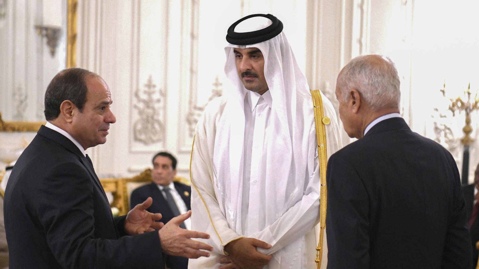 In this photo provided by Egypt's presidency media office, Egyptian President Abdel Fattah el-Sissi, left, and Secretary-General Ahmed Aboul Gheit, talk to Qatari Emir Sheikh Tamim bin Hamad Al Thani, during the International peace summit at the New Admin