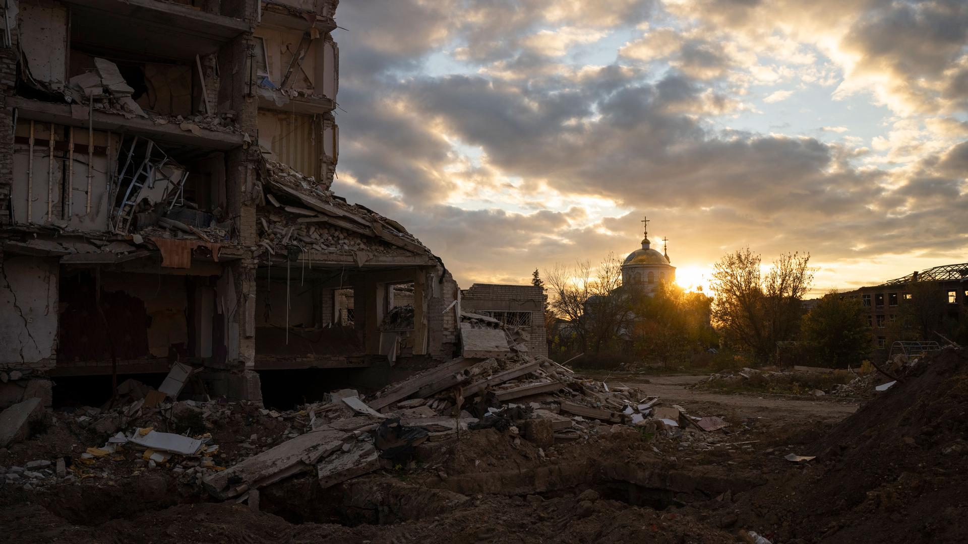 The sun sets over a destroyed building in Izyum, Ukraine, Tuesday, Oct. 24, 2023. 