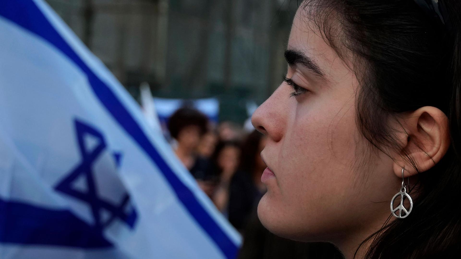 A woman wearing peace sign earrings takes part in a support rally outside the Jewish central Synagogue in the coastal town of Larnaca, Cyprus, on Tuesday, Oct. 17, 2023. 