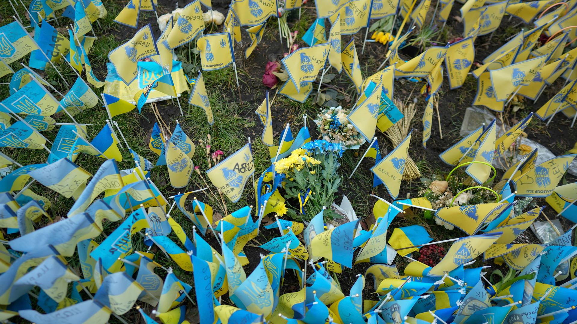 A bunch of flowers with the colors of the Ukrainian flag is laid down at the memorial for those killed during the war, near Maidan Square in central Kyiv, Ukraine, Friday, Feb. 24, 2023.