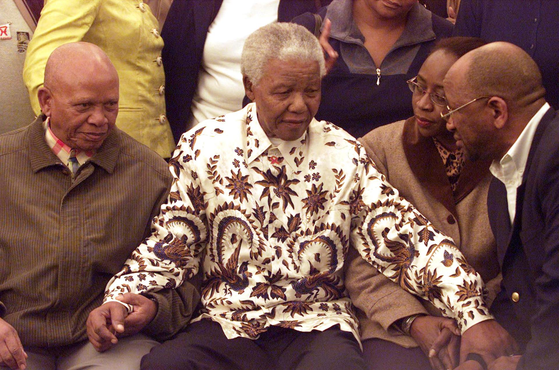 Former South African President Nelson Mandela, center, wears a printed shirt in Johannesburg, on July 18, 2003, as part of his 85th birthday celebrations. 