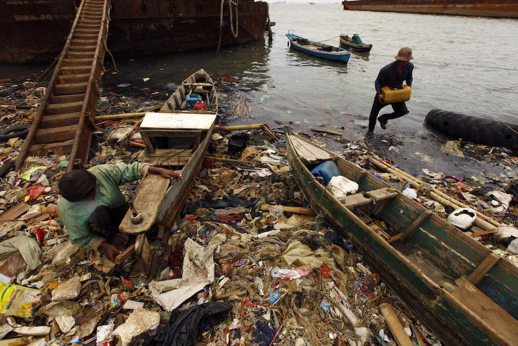 Indonesian fishermen on a polluted beach in Cilincing, North Jakarta, June 5, 2013.