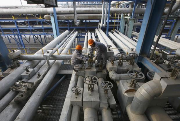 Employees close a valve of a pipe at a PetroChina refinery in Lanzhou, Gansu province January 7, 2011.
