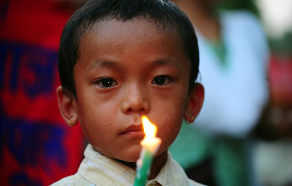A Nepalese boy holds a candle during a vigil for the victims of the devastating earthquake that struck on April 25.