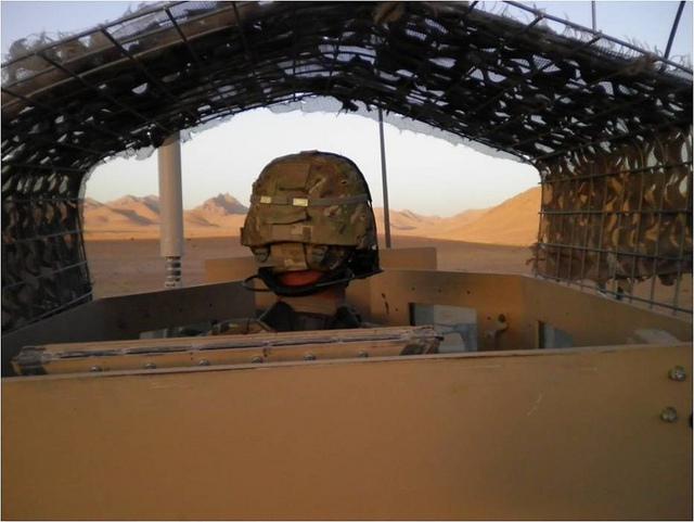 Spc. Jorge Villanueva, 2nd Battalion, 8th Field Artillery Regiment, 1st Stryker Brigade Combat Team, 25th Infantry Division, peers over the gunner's turret at Checkpoint 507 in the Daman District.