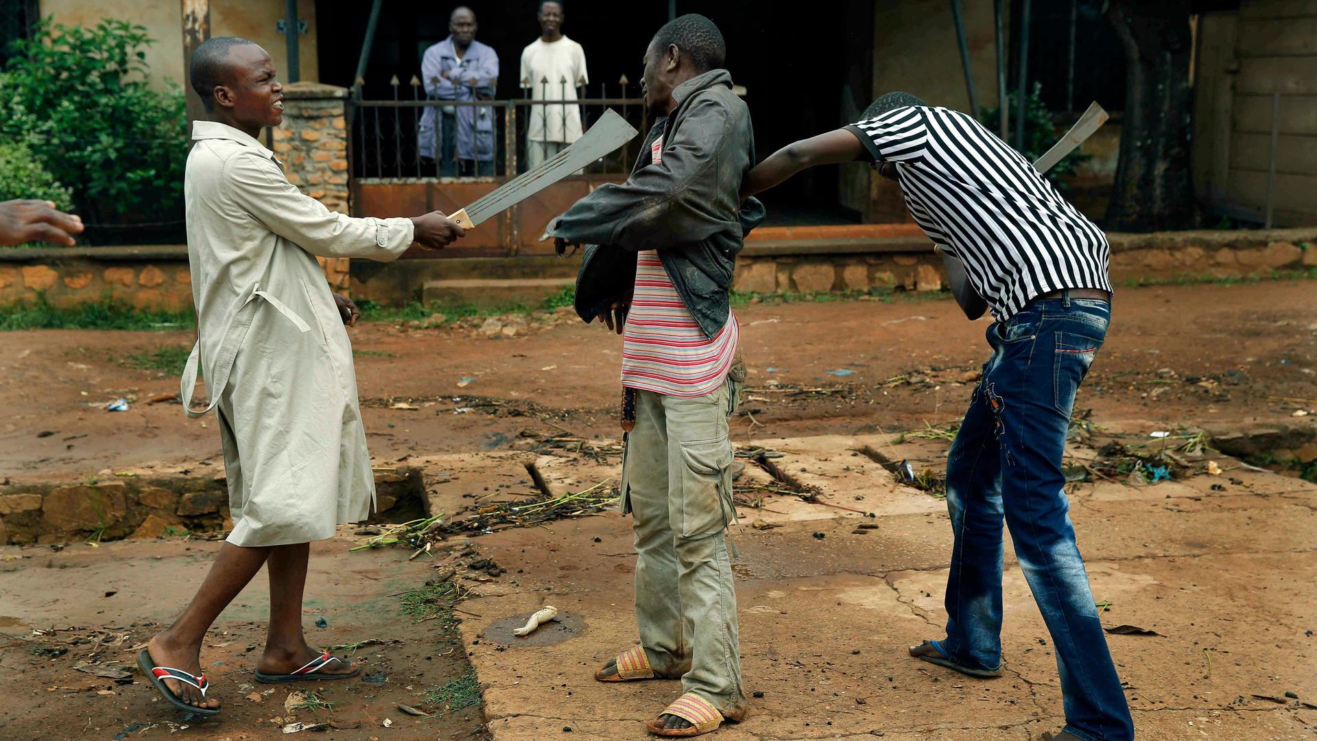 Muslim men organized in militias with machetes rough up a Christian man while checking him for weapons in the Miskine neighborhood of Bangui, Central African Republic.