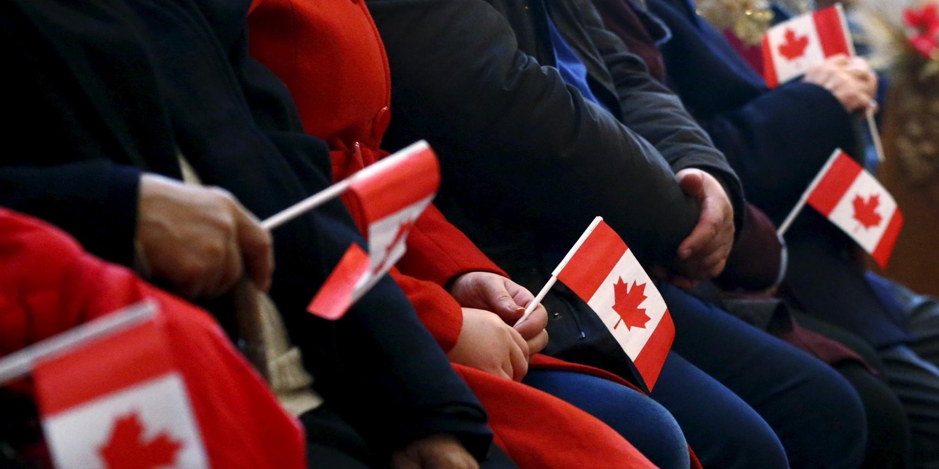 Syrian refugees hold Canadian flags