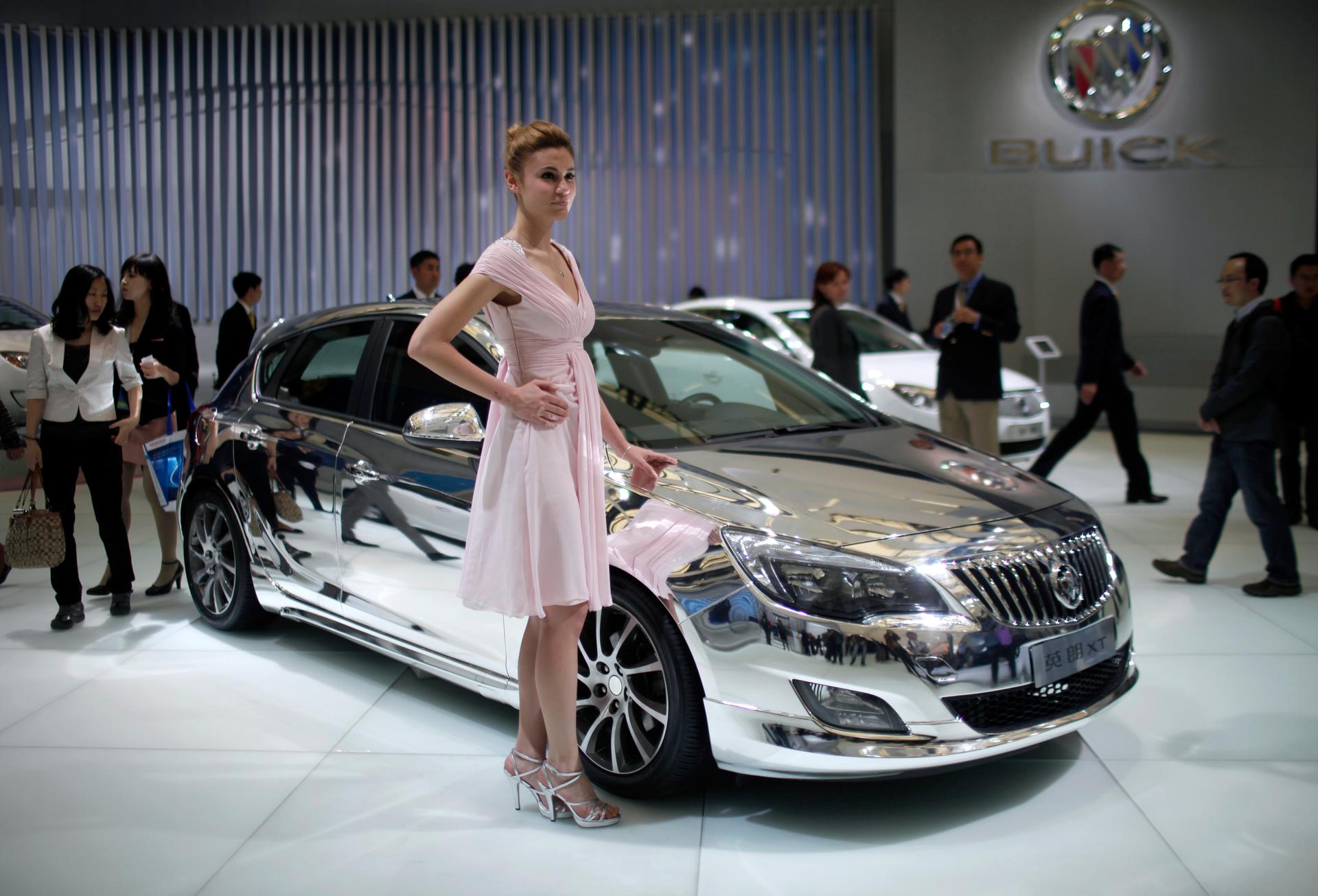 A model poses next to the Buick Excelle XT during the opening day of the Shanghai Auto Show April 19, 2011.