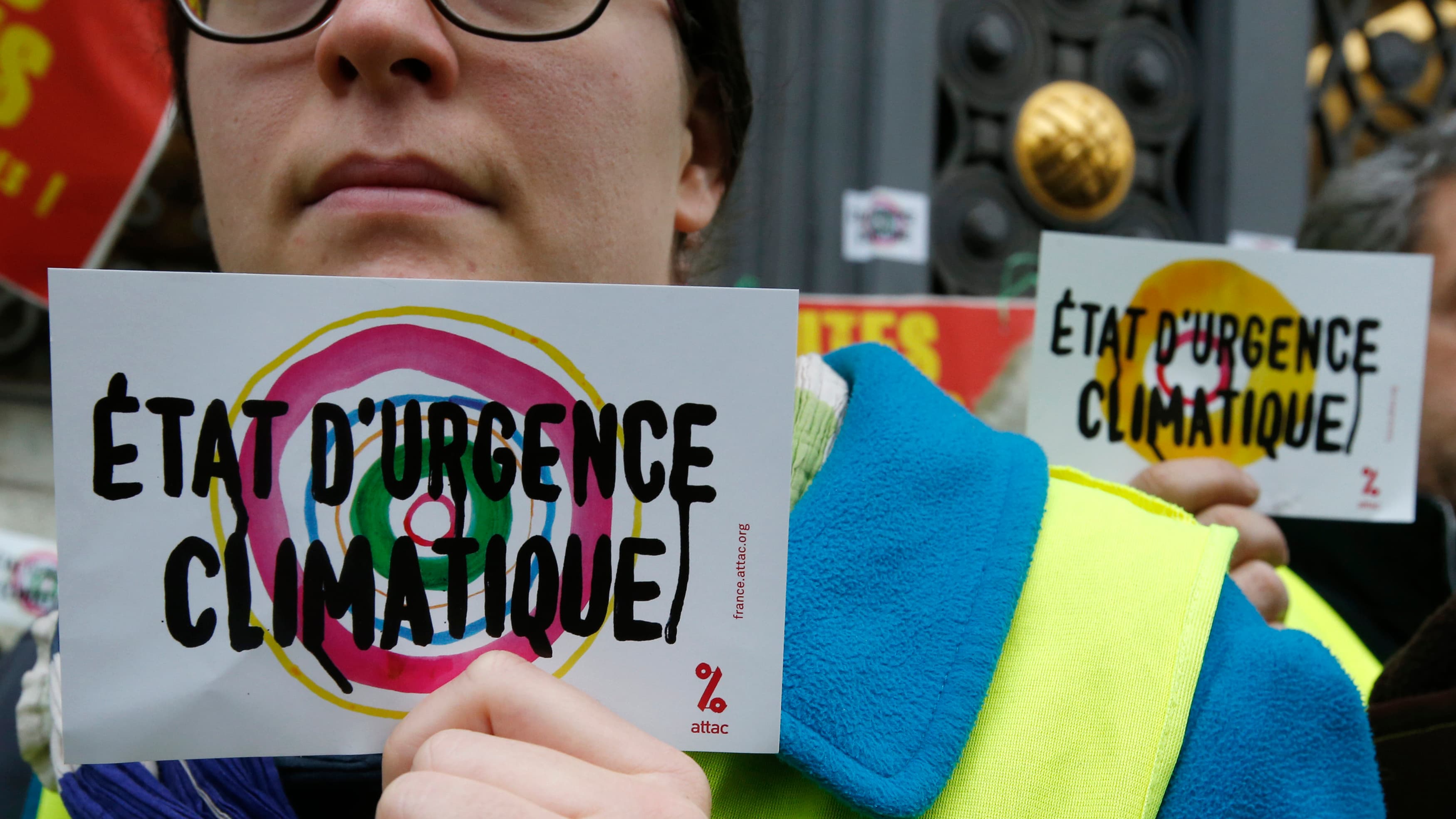 Environmental activists hold placards reading "Climatic emergency state" during a demonstration as part of the World Climate Change Conference 2015 (COP21) in Paris.