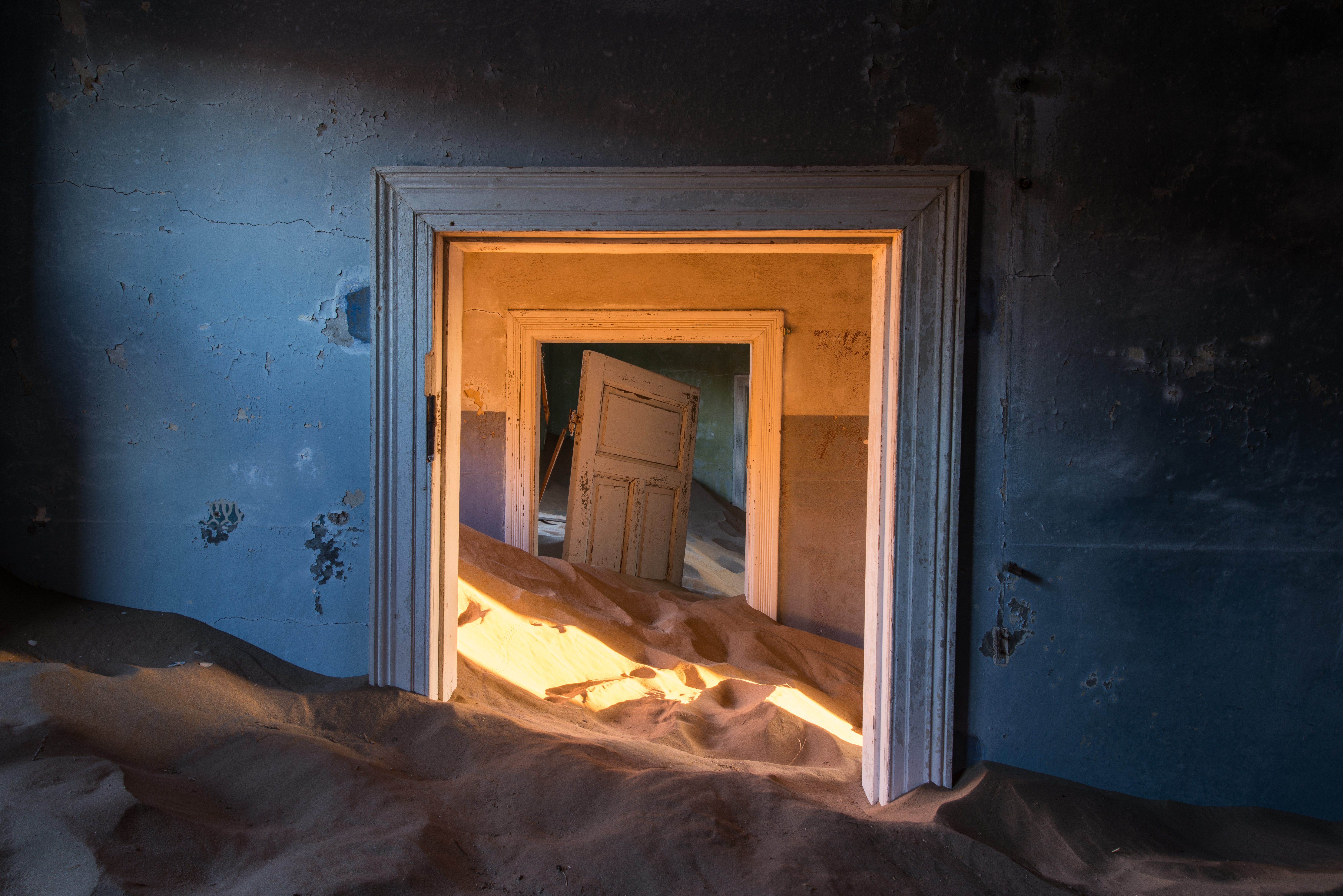 A doorway half-buried by sand in Kolmanskop, Namibia
