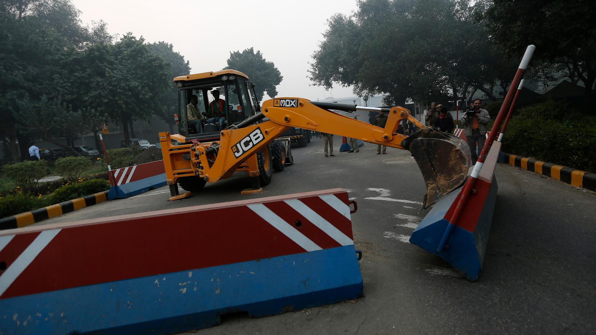 A bulldozer removes the security barriers in front of the US embassy in New Delhi