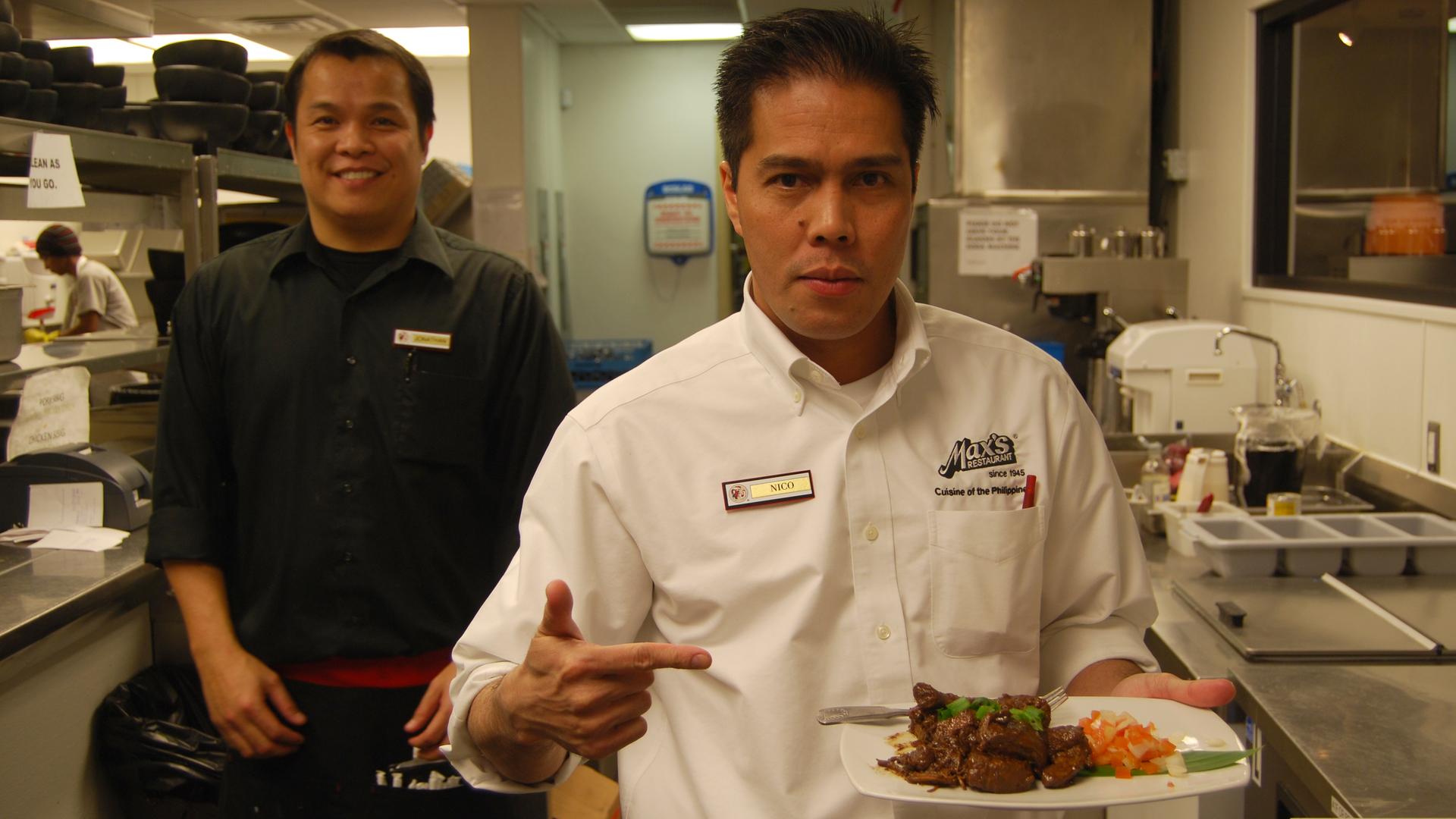 Nico Vidal, manager at the new Las Vegas Max's, a well-known Philippine chain that's opening new locations in the US and Canada. Vidal is holding a plate of Pinatuyong Pork Adobo.