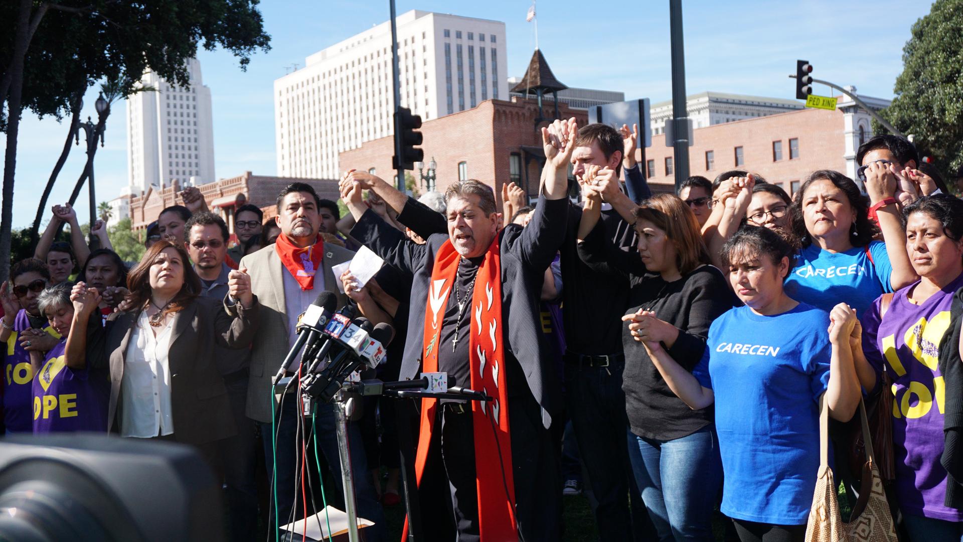 Rev. Walter Contreras of the National Latino Evangelical Coalition leads immigration rights activists in prayer at a rally in downtown Los Angeles.