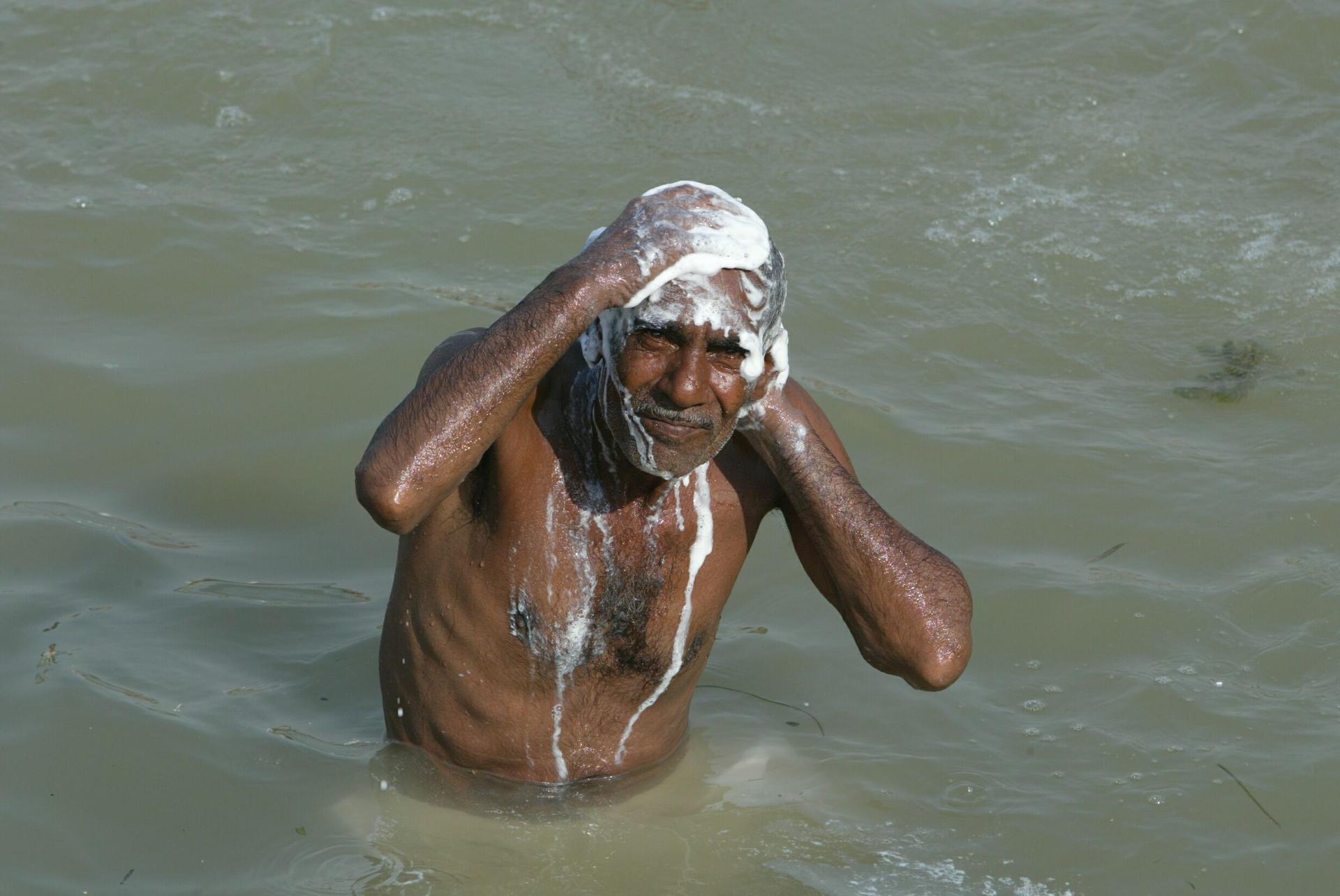 An Iraqi man bathes himself in a canal in Iraq's second largest city Basra, when electricity was cut off, August 11, 2003