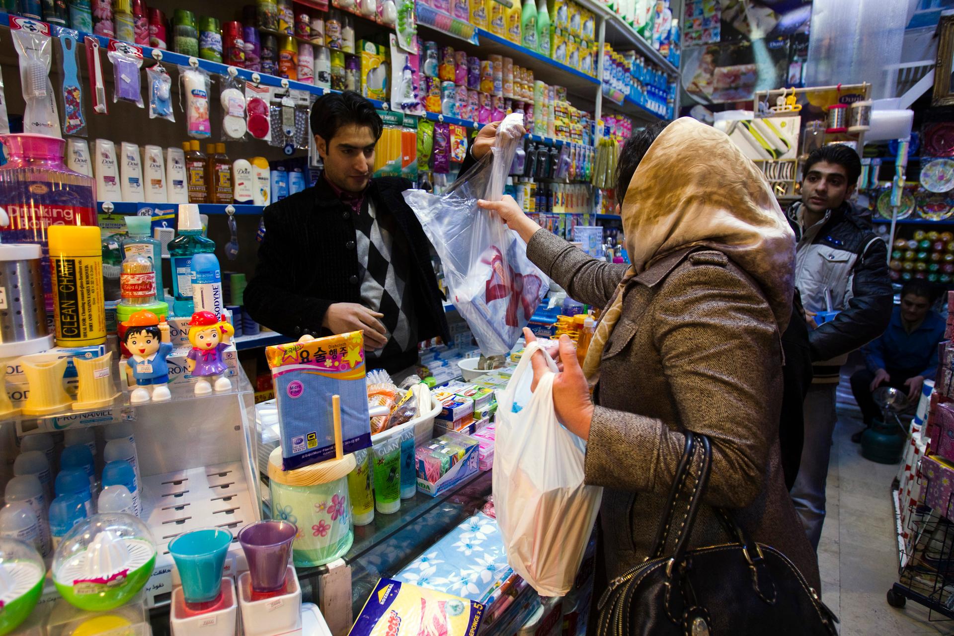 A woman makes a purchase at a store in Tehran.
