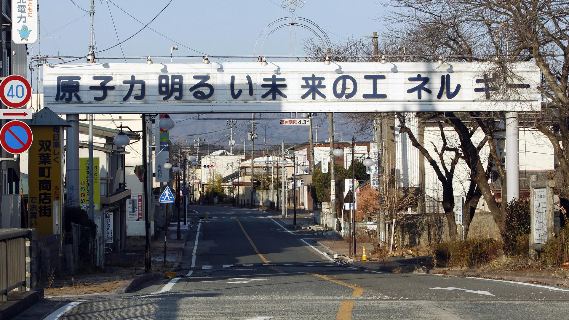 A sign reading "Nuclear Power - The Energy for a Better Future" hangs over a street in the town of Futaba, inside the 12-mile radius exclusion zone around Japan’s crippled Fukushima Daiichi nuclear power plant in a 2012 photo.