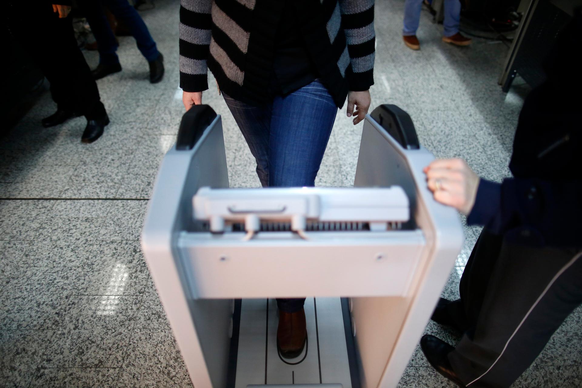 A woman goes through security checks at the Sarajevo International Airport in Sarajevo February 26, 2014.