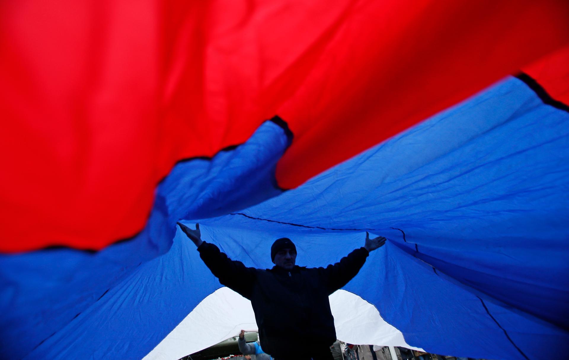 Demonstrators unfurl  a giant Russian flag during a pro-Russian rally in Simferopol, Crimea.
