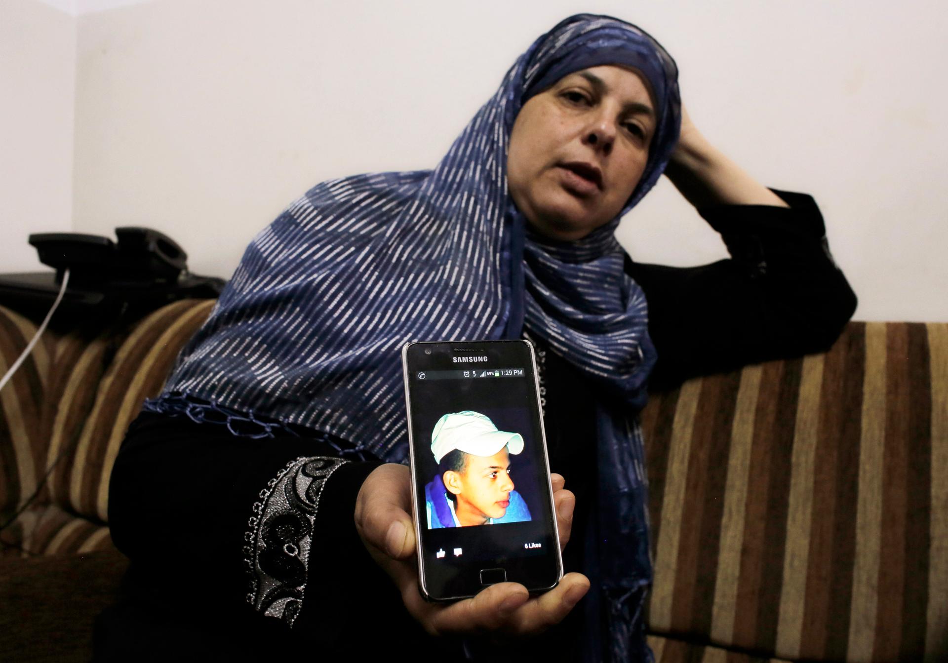 Suha, mother of 16 year-old Mohammed Abu Khudair, shows a picture of her son on her mobile phone at their home in Shuafat, an Arab suburb of Jerusalem. News of the discovery of Mohammed's body sparked clashes on Wednesday between rock-throwing Palestinian