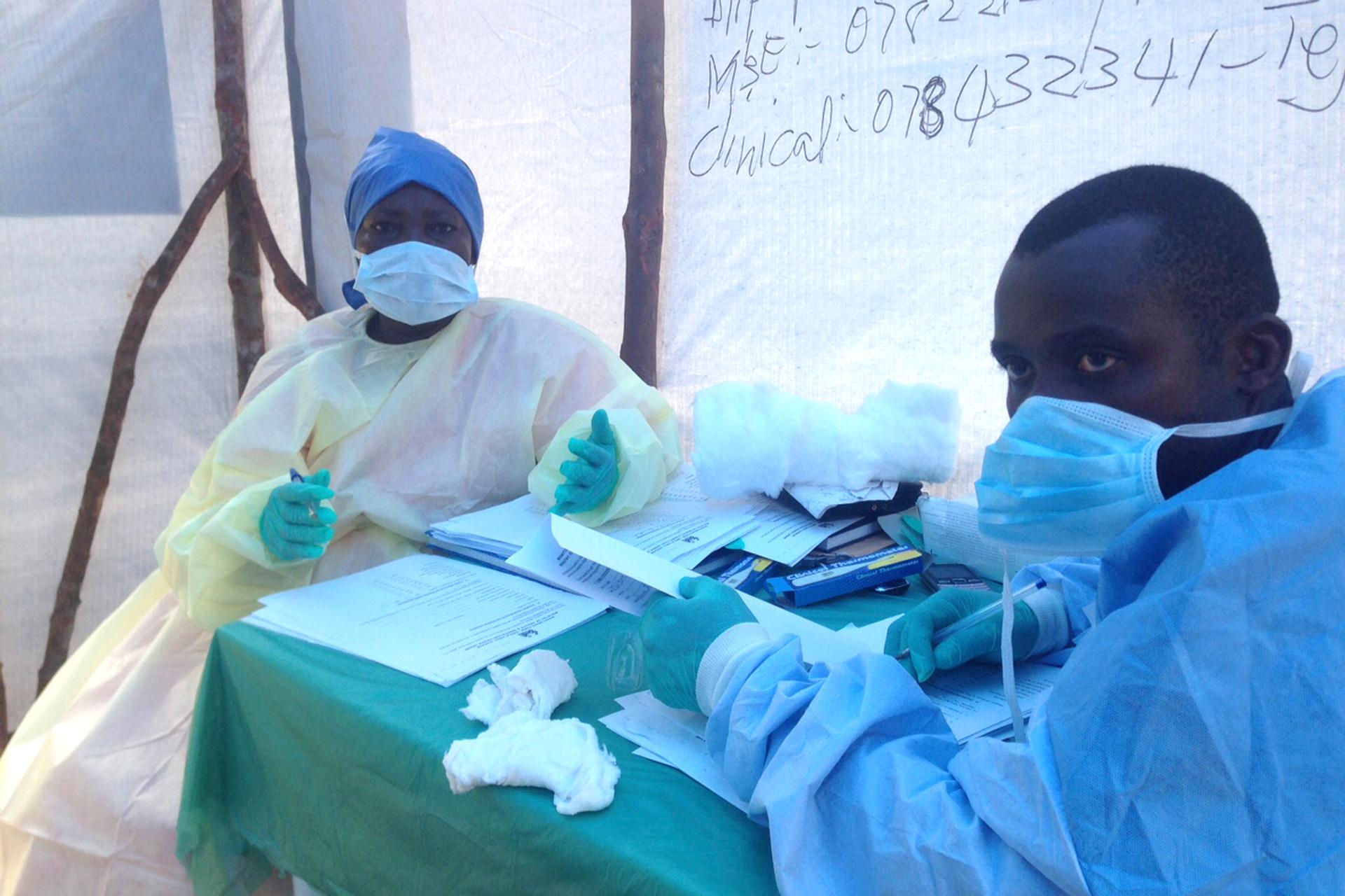 Government health workers are seen during the administration of blood tests for the Ebola virus in Kenema, Sierra Leone, on June 25, 2014.