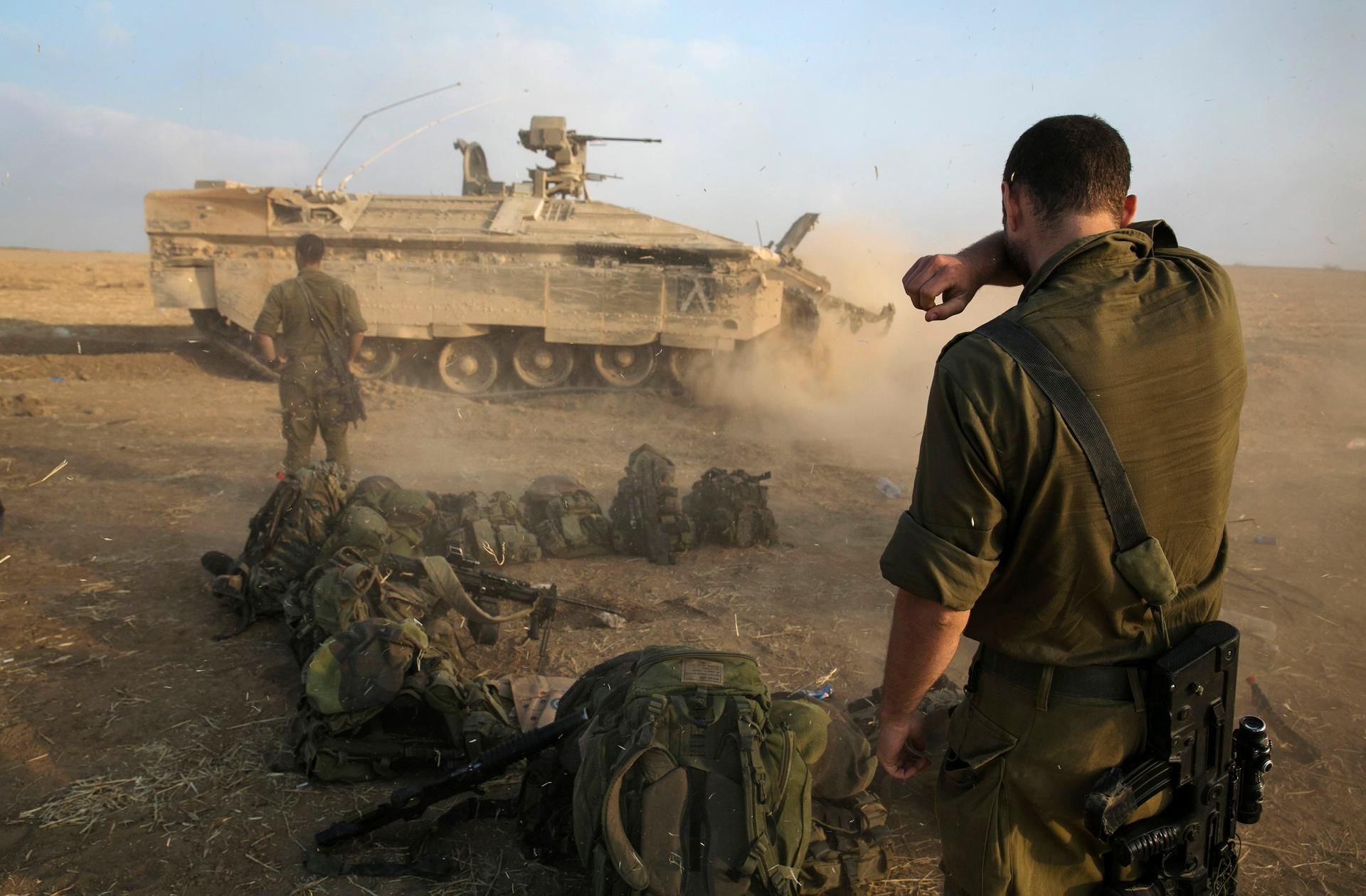 An Israeli soldier stands at a staging area after crossing back into Israel from Gaza on July 28, 2014.