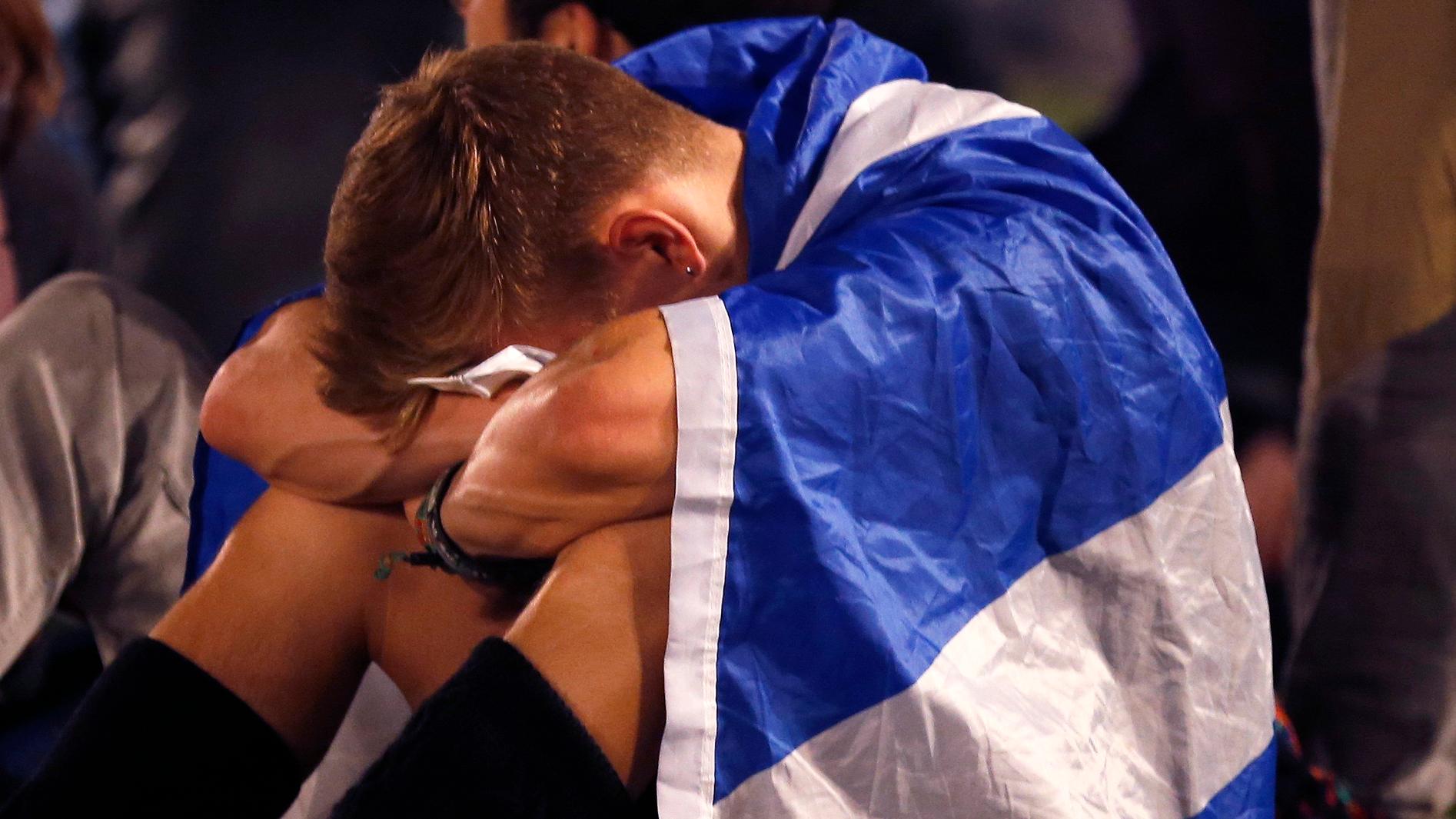 A supporter from the "Yes" Campaign cries into his knees as he sits in George Square in Glasgow, Scotland September 19, 2014. The "Yes" Campaign bid to win independence for Scotland, failed.