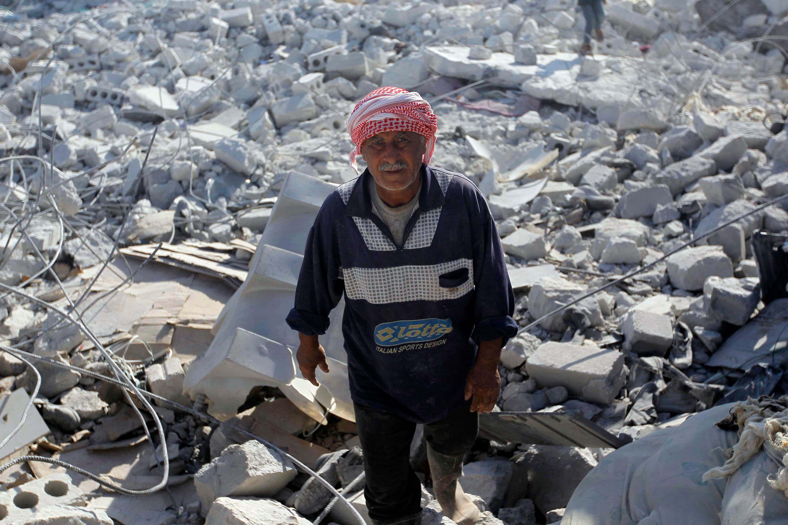 A man inspects a damaged site in what activists say was a US strike in Kfredrian, Idlib province, Syria, on September 23, 2014.