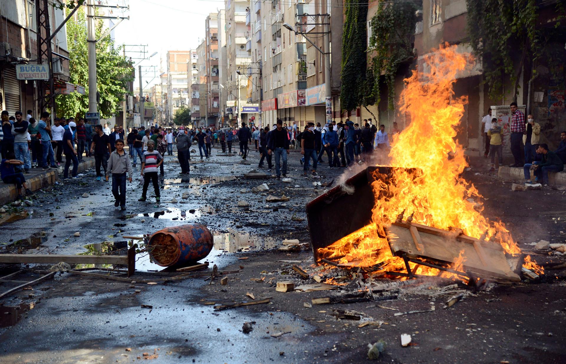 Kurdish protesters set fire to a barricade blocking the street as they clash with riot police in Diyarbakir, Turkey, on October 7, 2014.