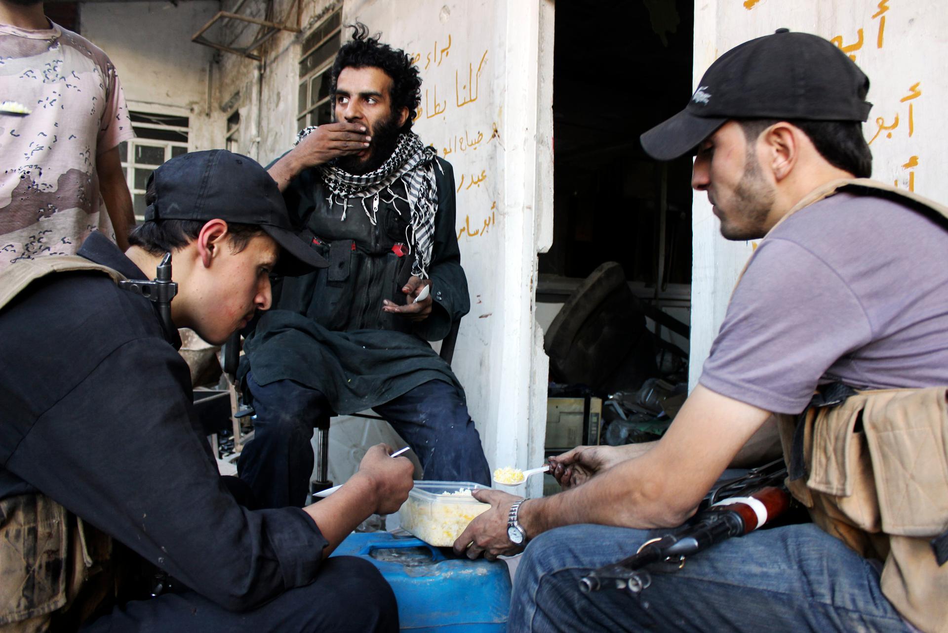 Rebel fighters eat in the Damascus suburb of Arbeen October 6, 2014.
