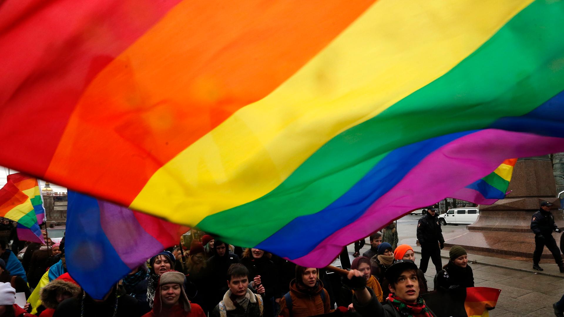 Gay rights protestors fly the rainbow flag