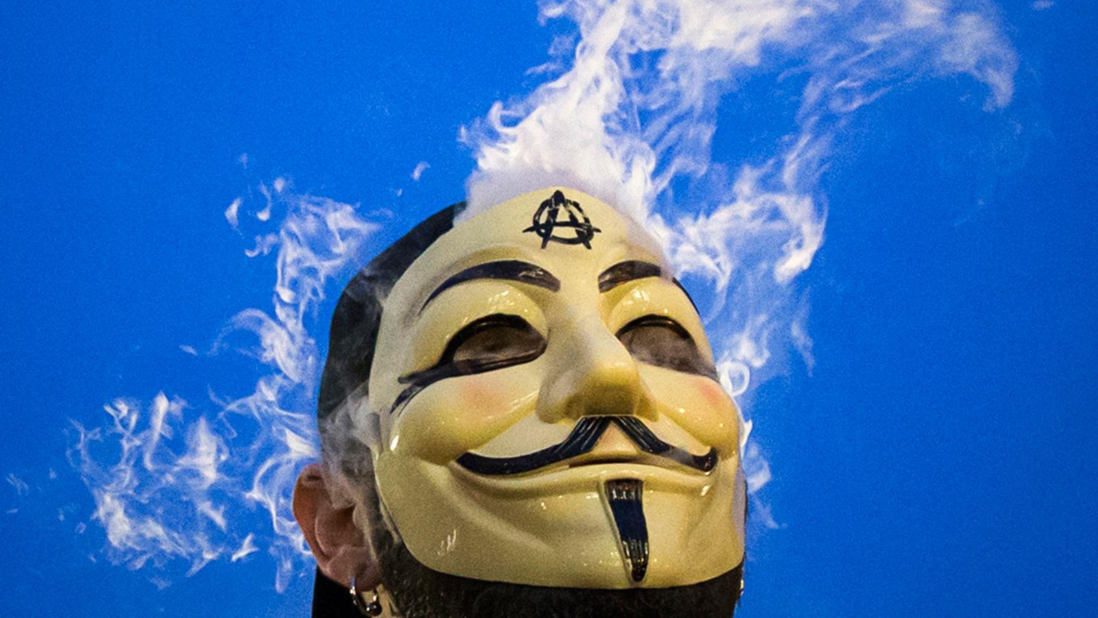 A man in a Guy Fawkes mask smokes while joining supporters of the Anonymous movement taking part in the global "Million Mask March" protests in New York, on November 5, 2014.