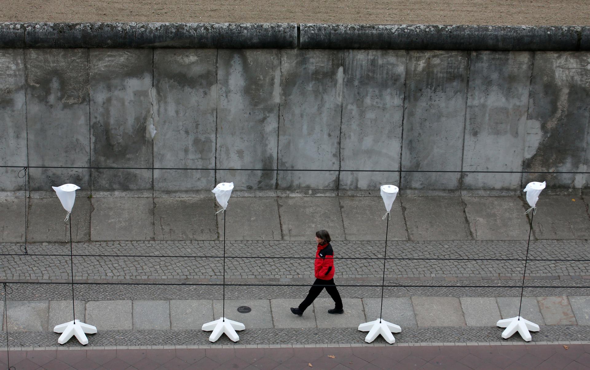 A part of the inner city of Berlin will be temporarily divided from November 7 to 9, 2014, with a light installation featuring 8,000 luminous white balloons to commemorate the 25th anniversary of the fall of the Berlin Wall. Here a woman walks in front of