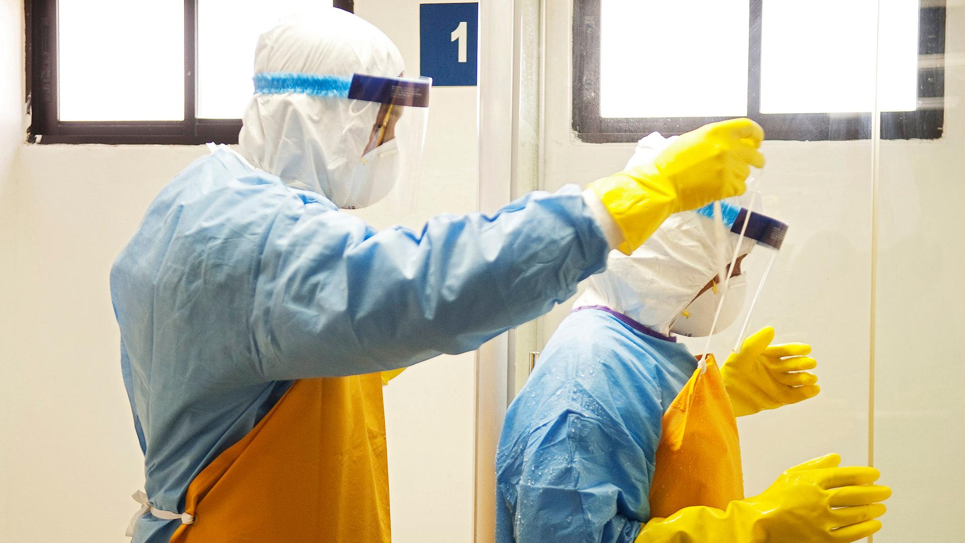 Doctors help each other with their protective suits during an Ebola virus drill in Santo Domingo, Dominican Republic.