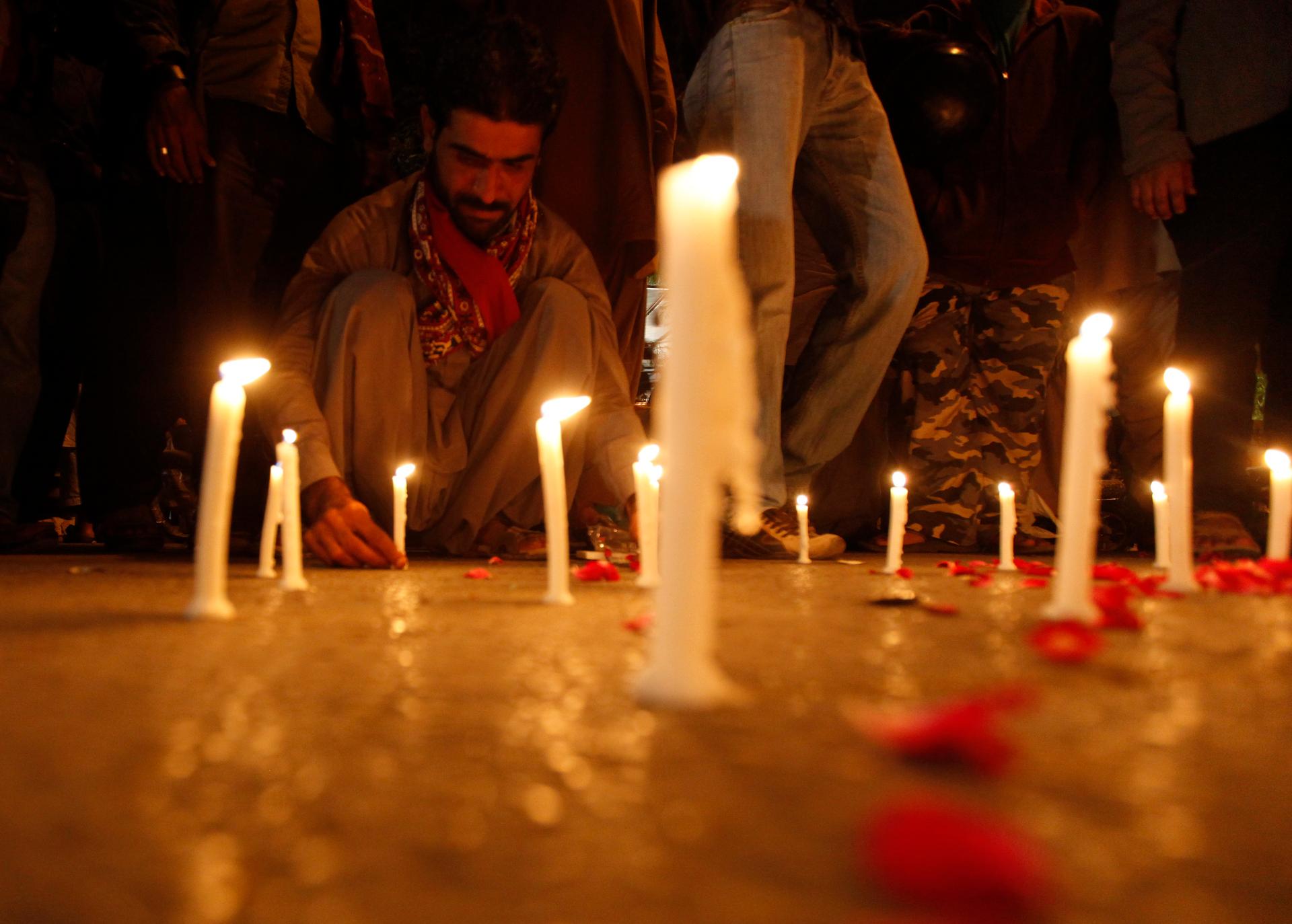 A man lights candles to mourn the victims from the Army Public School in Peshawar, which was attack by Taliban gunmen, in Karachi, December 16, 2014.