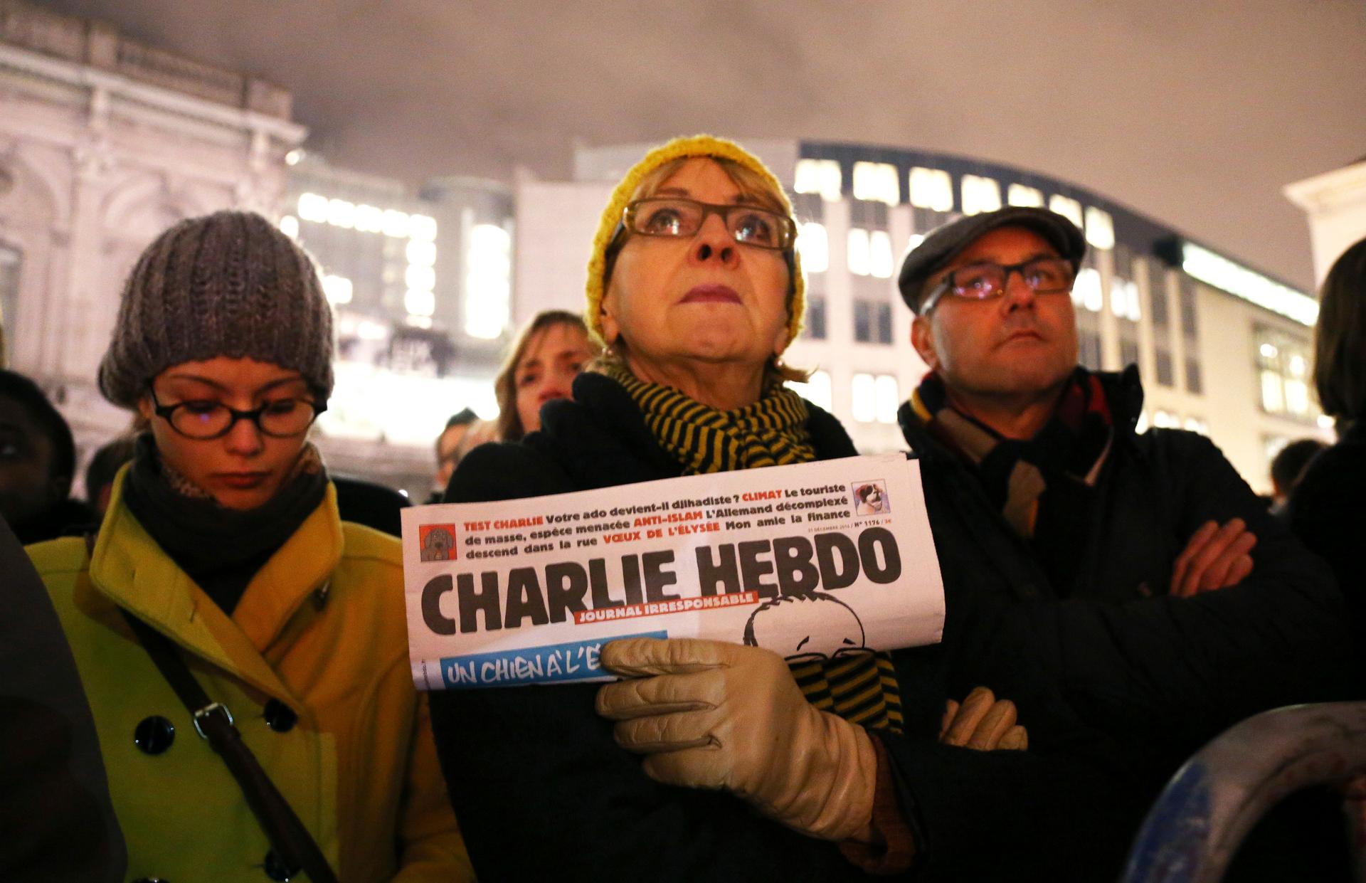 In Brussels, a woman holds a copy of Charlie Hebdo to pay tribute to the victims of a shooting at the offices of the weekly satirical magazine in Paris on January 7, 2015.