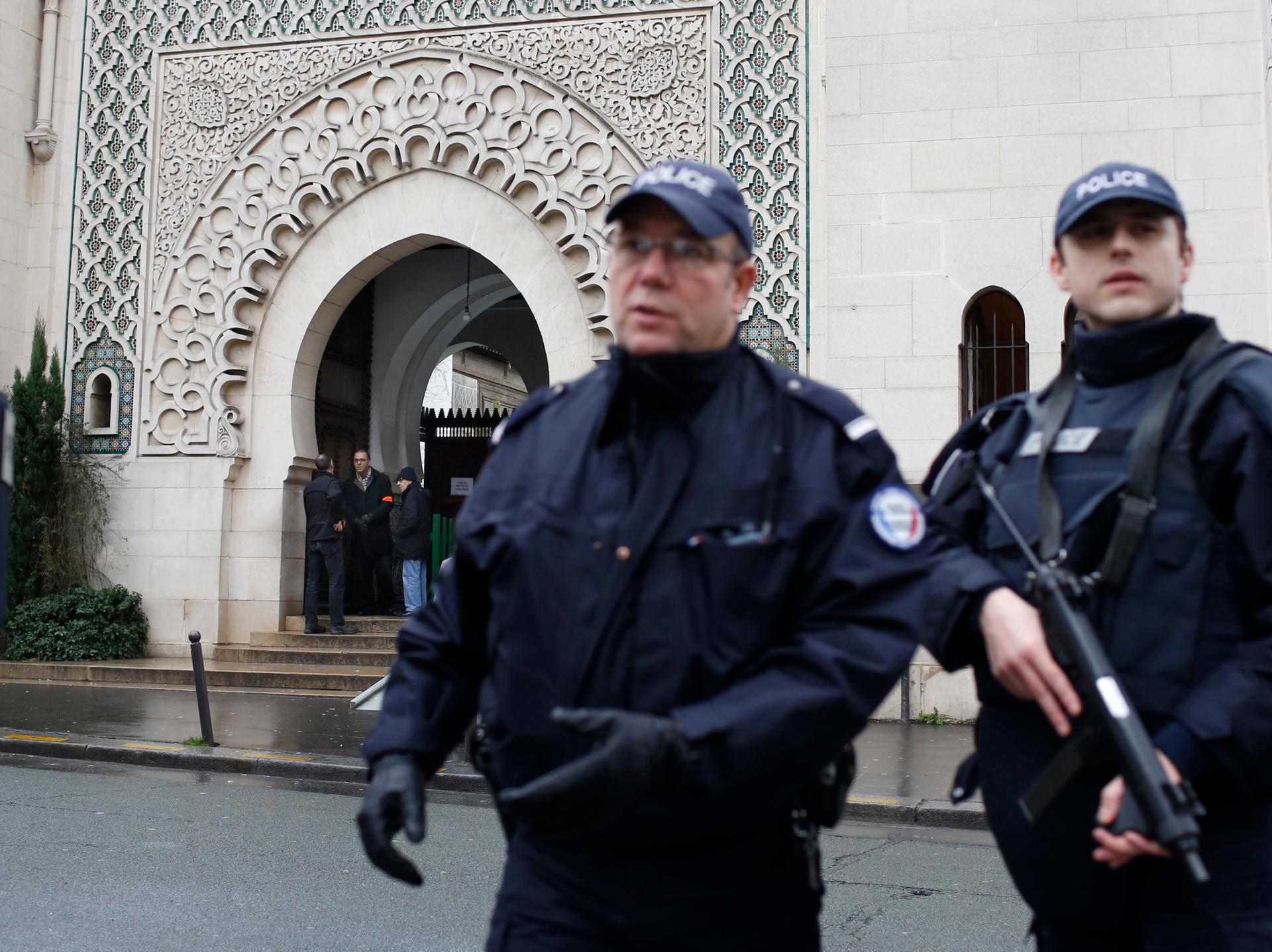 French police stand in front of the entrance of Paris Mosque as Muslims gather for Friday prayers in the French capital on January 9, 2014.