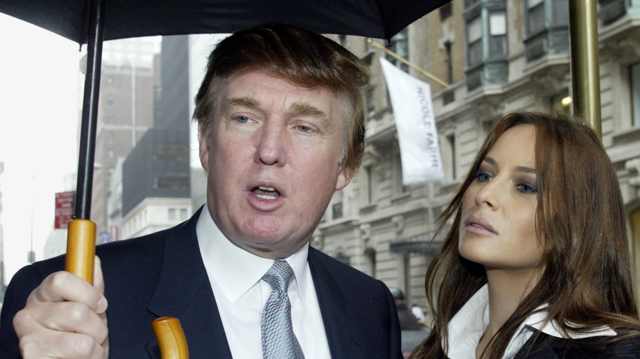 Donald Trump and Melania Trump under an umbrella