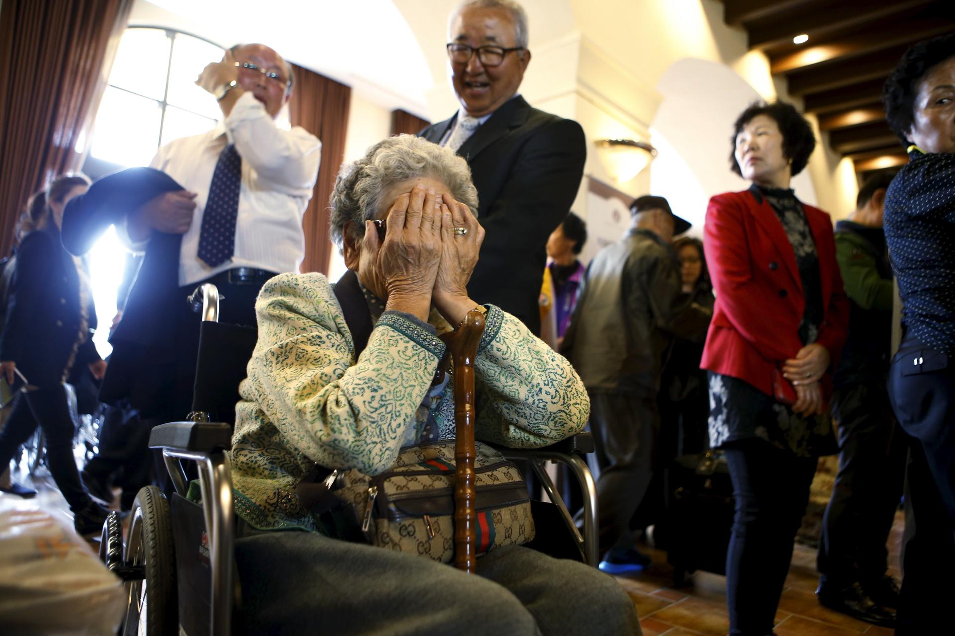 A woman (C), who is selected as a participant for a reunion, reacts at a hotel used as a waiting place in Sokcho, South Korea, October 19, 2015.