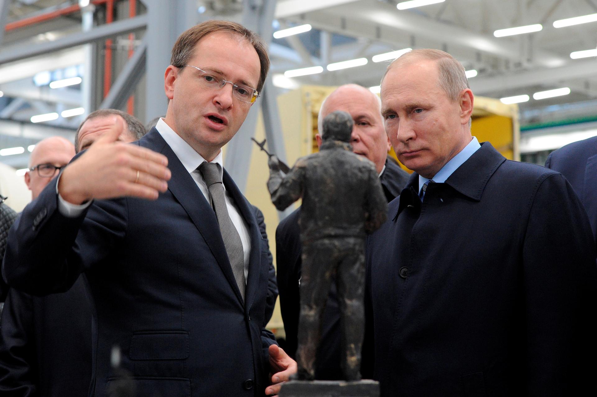 Russian President Vladimir Putin (R) listens to Culture Minister Vladimir Medinsky as they watch the project of a monument to Mikhail Kalashnikov.