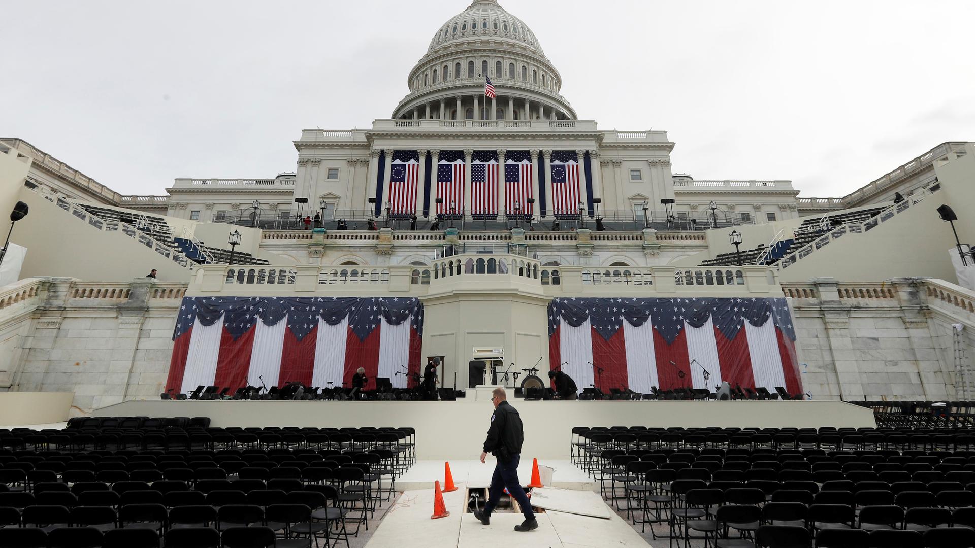 Man in front of Capitol building draped in American flags